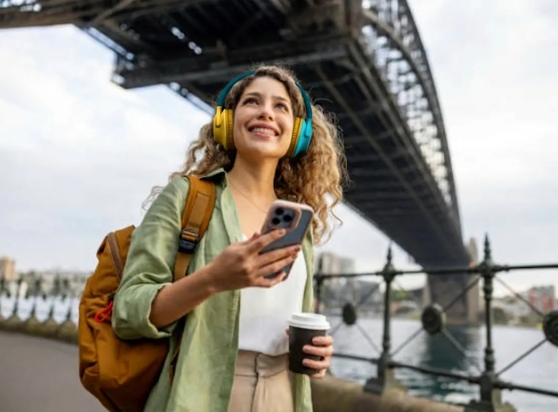 A traveler with headphones listening to a Parroo audio story.